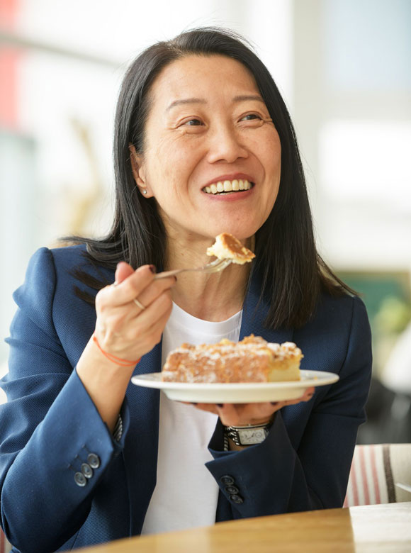 Frau isst ein Stück Kuchen in Bohne & Co. Store auf Sylt